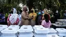 Para relawan Asosiasi Komunitas Muslim Miami dan Yayasan Lumba-Lumba Miami mendistribusikan makanan buka puasa Ramadhan di Miami Gardens, Florida, Amerika Serikat, Selasa (27/4/2021). Distribusi makanan dilakukan secara drive thru. (CHANDAN KHANNA/AFP)