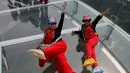 Dua turis berselfie saat mengunjungi wahana platform kaca di Shilin Gorge, Beijing, Cina, (27/5). Platform kaca ini merupakan yang terpanjang di dunia mengalahkan Grand Canyon. (REUTERS/Kim Kyung-Hoon)