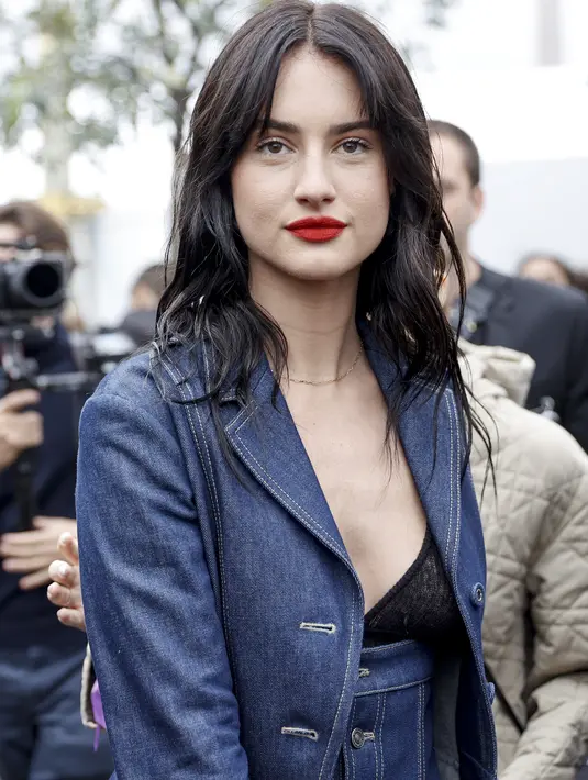 Grace Van Patten tiba menghadiri acara busana ready-to-wear Spring/Summer 2023 Dior yang dipresentasikan di Paris, Selasa, 27 September 2022.  Ia tampil cantik mengenakan setelan jeans biru dengan bibir merahnya. (AP Photo/Lewis Joly)