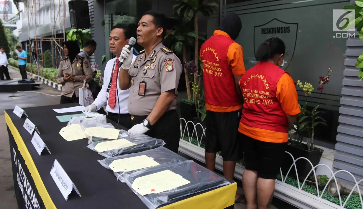Kabid Humas Polda Metro Jaya Kombes Pol Argo Yuwono menunjukkan barang bukti di Polda Metro Jaya, Jakarta, Rabu (18/4). Subdit Cyber Crime Ditreskrimsus menangkap WNA Nigeria pelaku penipuan melalui Facebook dan WhatsApp. (Liputan6.com/Arya Manggala)