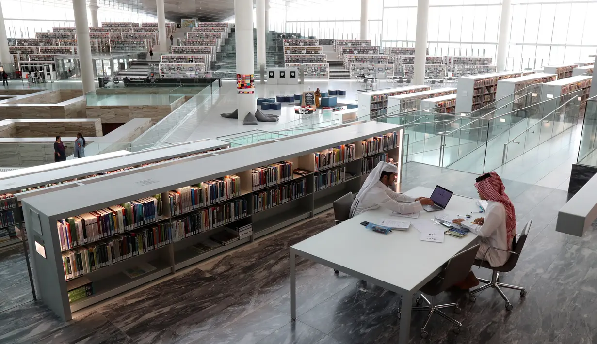 Dua pria berdiskusi saat mengunjungi Perpustakaan Nasional Qatar di ibu kota Doha pada 19 Mei 2019. Dengan lebih dari 1 juta buku cetak dan 500 ribu edisi digital, perpustakaan ini merupakan yang terbesar di Timur Tengah. (KARIM JAAFAR / AFP)
