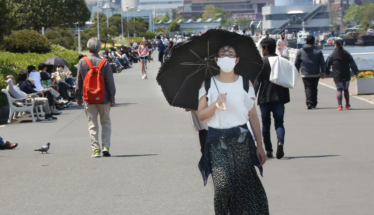 <p>Seorang wanita mengenakan masker berjalan selama pandemi Covid-19 di sebuah taman di Yokohama, dekat Tokyo, (29/4/2020). PM Jepang Shinzo Abe memperluas keadaan darurat ke seluruh Jepang dari hanya Tokyo dan perkotaan lainnya. daerah sebagai virus terus menyebar. (AP /Koji Sasahara)</p>