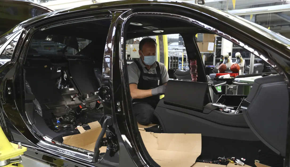 Pekerja merakit mobil Mercedes-Benz S-class di pabrik Mercedes, Sindelfingen, Jerman, Kamis (30/4/2020). Mulai 27 April 2020, Mercedes-Benz kembali membuka jalur produksi yang sebelumnya ditutup karena pandemi virus corona COVID-19. (AP Photo/Matthias Schrader)