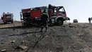 Petugas mengamati mobil pemadam kebakaran yang dilalap api, dekat Kalyvia, Yunani, Kamis (3/8). Angin kencang dengan kecepatan 60 kilometer per jam menghambat usaha pemadaman kebakaran , sementara suhu mencapai 35 derajat celcius. (AP/Thanassis Stavrakis)