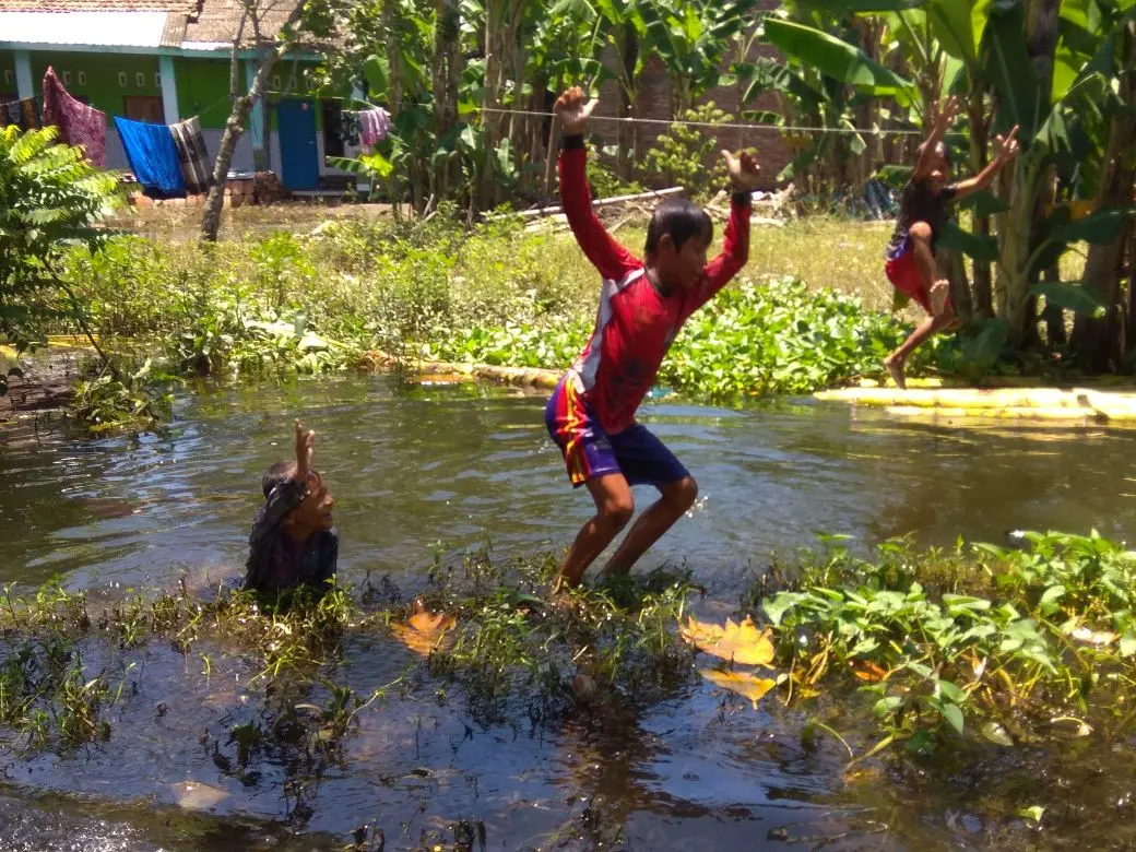 Anak-anak desa Kalisari bergembira dengan bermain dan mandi air banjir. (foto : Liputan6.com / edhie)