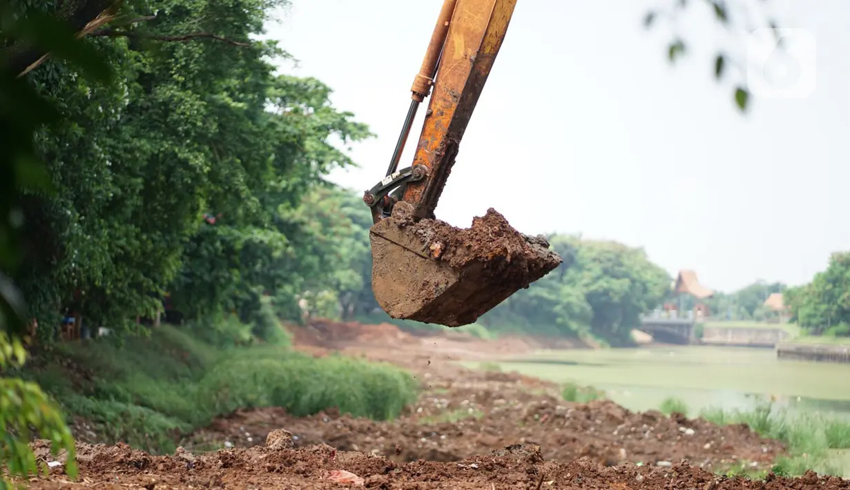 Petugas menggunakan alat berat untuk mengeruk lumpur di kawasan Setu Babakan, Jakarta, Rabu (21/10/2020). Program pengerukan lumpur kali, sungai, atau waduk di Jakarta bertujuan untuk mencegah banjir serta mengantisipasi adanya genangan air saat musim penghujan. (Liputan6.com/Immanuel Antonius)