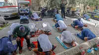 Anggota pasukan keamanan Israel berjaga saat seorang jemaah Palestina melaksanakan salat Jumat selama bulan suci Ramadan di tengah krisis pandemi coronavirus di luar kompleks masjid al-Aqsa di Kota Tua Yerusalem (15/5/2020). (AFP/Ahmad Gharabli)