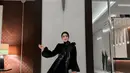 Sementara saat momen resepsi, Fairuz A Rafiq menunjukkan pesona elegan dalam balutan maxi dress dan hijab serba hitam. [@fairuzarafiq].