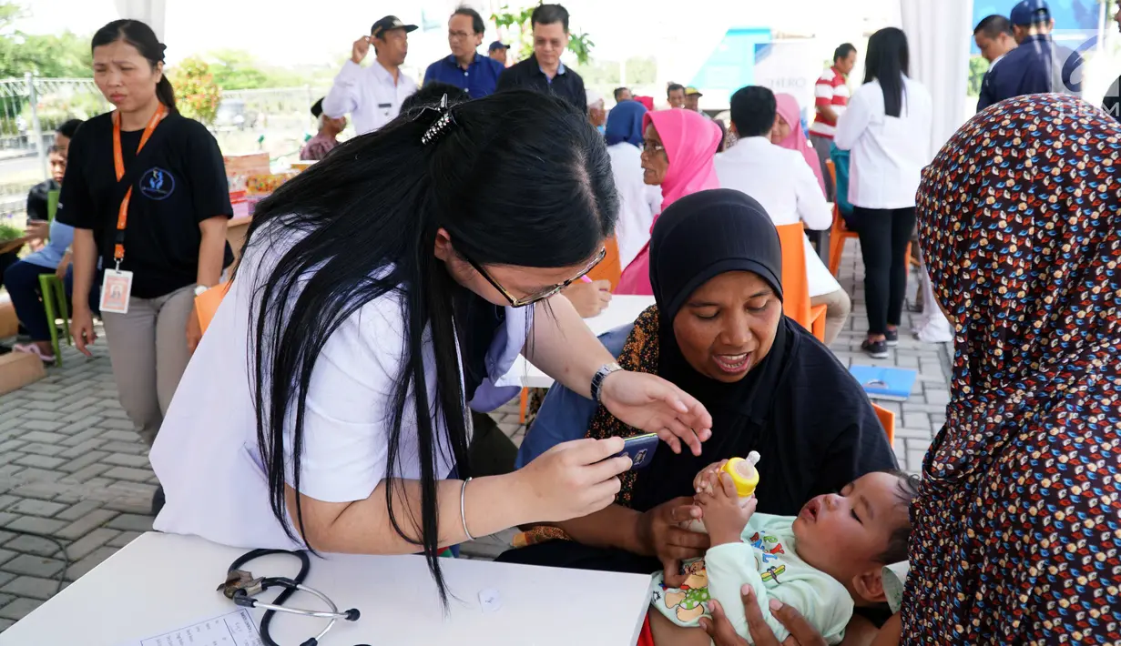 Batita sedang diperiksa kesehatannya di Mataram, NTB, Rabu (15/8). PT Hero Supermarket Tbk memberikan bantuan dan dukungan kepada lingkungan di sekitar toko yang terkena dampak bencana gempa bumi di Lombok Utara. (Liputan6.com/HO/Eko)