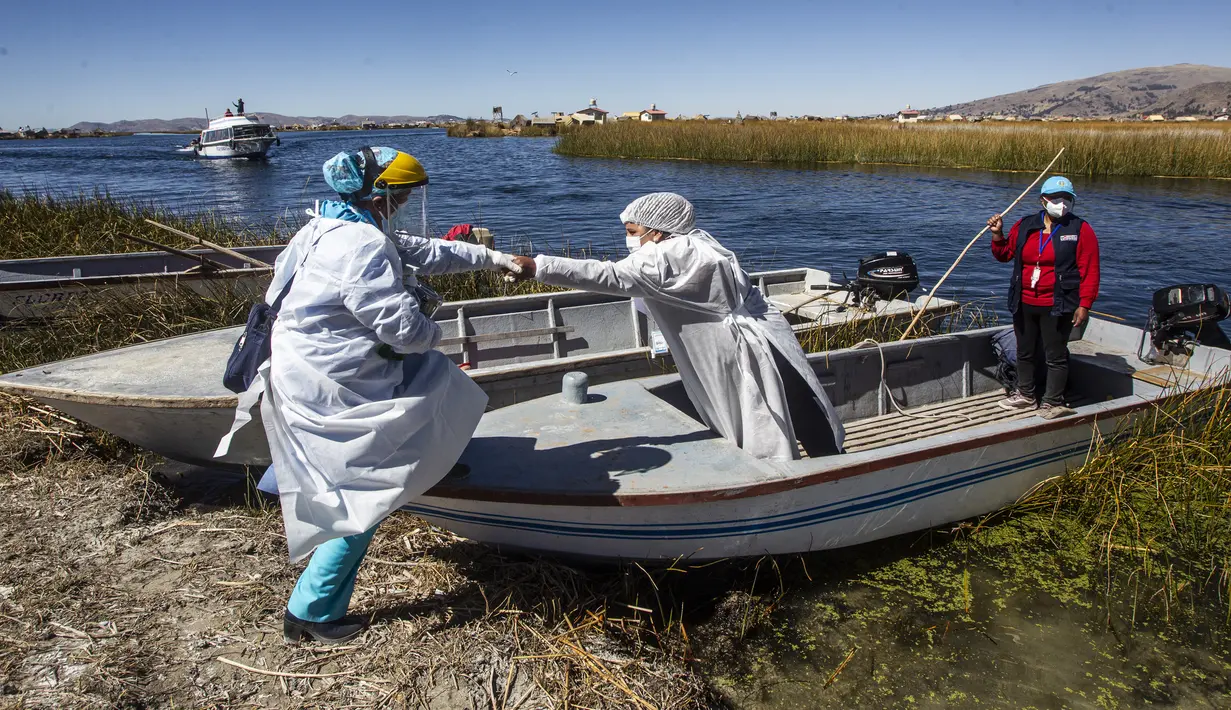 Petugas kesehatan tiba di pulau Uros untuk menyuntik warga dengan vaksin COVID-19 Sinopharm, di danau Titicaca di Puno, Peru, pada 7 Juli 2021. Peru memulai vaksinasi COVID-19 untuk ratusan penduduk asli yang tinggal di pulau terapung Uros, di Danau Titicaca. (Carlos MAMANI / AFP)