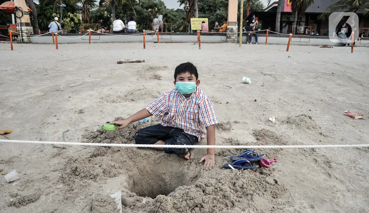 Seorang anak bermain pasir saat berwisata di Pantai Lagoon, Ancol, Jakarta, Kamis (21/10/2021). Salah satu aturan PPKM yang disesuaikan Pemprov DKI Jakarta adalah kembali dibukanya tempat bermain anak dan pusat hiburan. (merdeka.com/Iqbal S. Nugroho)
