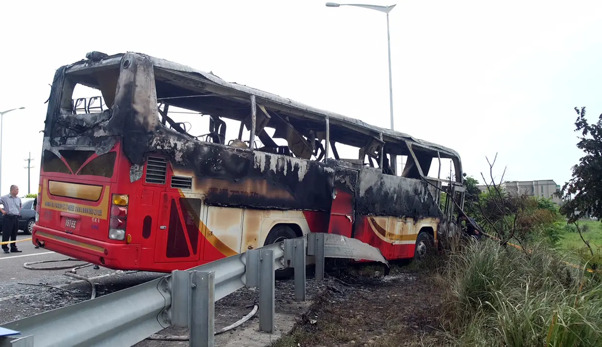 Sebuah bus pariwisata yang membawa wisatawan asal China menabrak pagar jalan raya dan terbakar dalam perjalanan ke Taoyuan, sebuah bandara utama di selatan Ibu Kota Taipei, Taiwan, Selasa (19/7). Insiden ini menewaskan setidaknya 26 orang. (Sam YEH/AFP)
