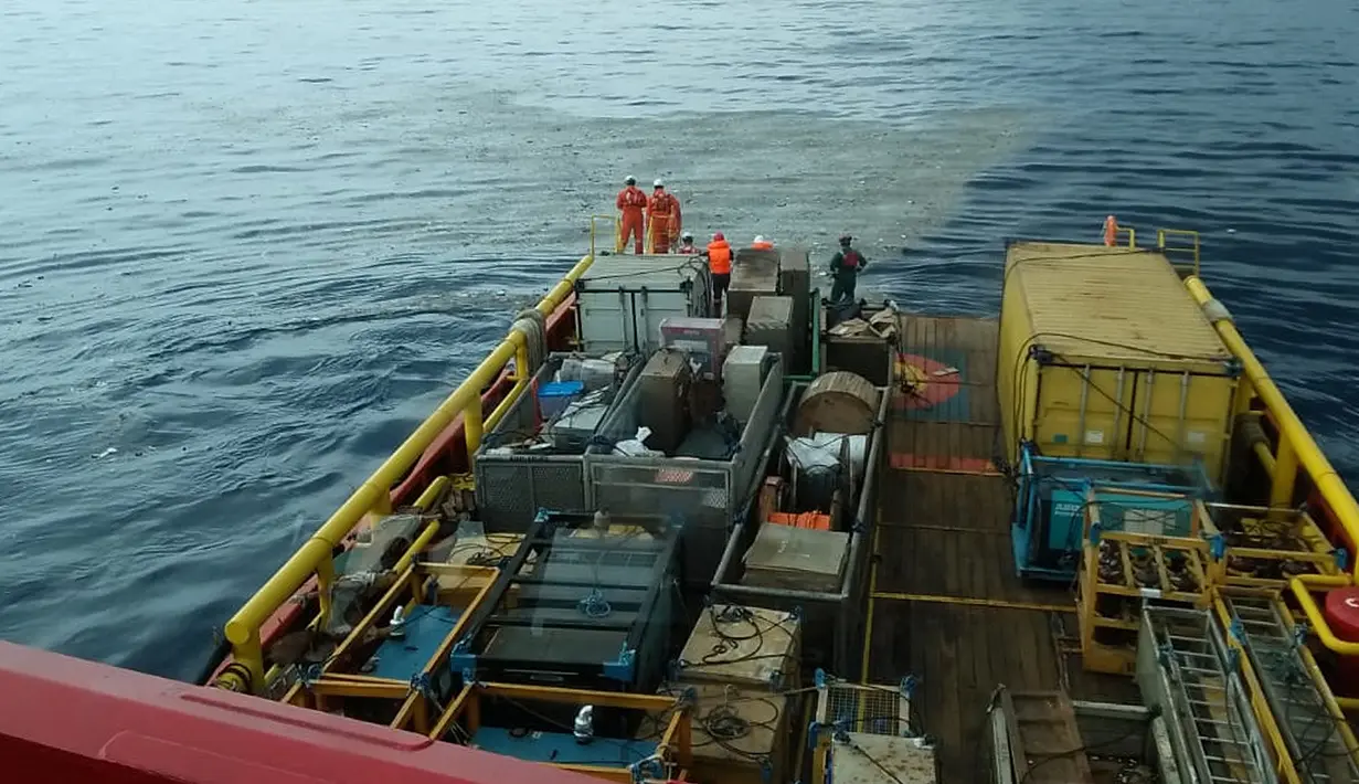 Awak kapal Pertamina mengamati serpihan pesawat Lion Air bernomor penerbangan JT610 rute Jakarta-Pangkalpinang yang jatuh di laut utara Karawang, Jawa Barat, Senin (29/10). (HO/NATIONAL DISASTER MITIGATION AGENCY/PERTAMINA HULU ENERGY / AFP)