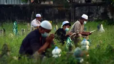 Orang-orang berdoa di sebelah makam kerabat saat perayaan Hari Raya Idul Adha di sebuah pemakaman di Provinsi Narathiwat, Thailand, Rabu (21/7/2021). Setiap Idul Adha atau hari besar Islam lainnya, sebagian warga banyak mendatangi kuburan untuk mendoakan keluarganya. (Madaree TOHLALA/AFP)