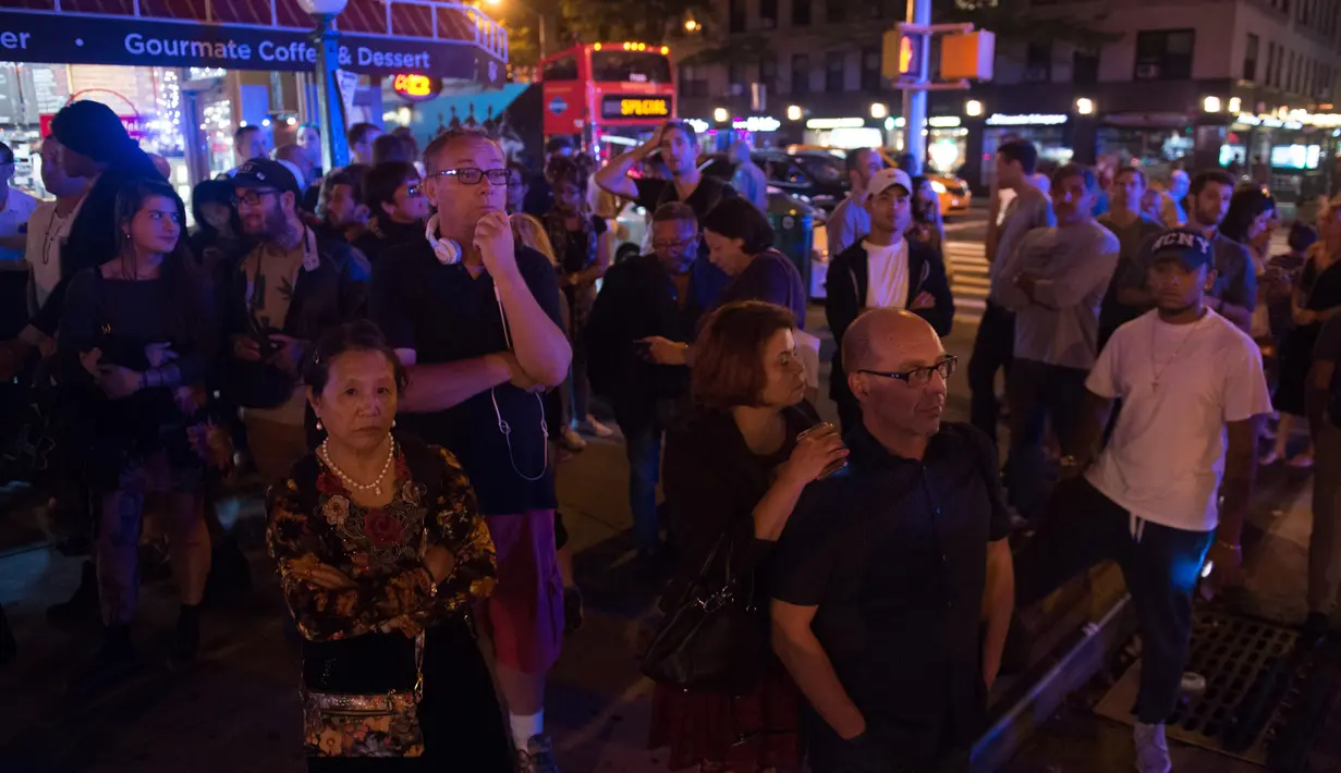 Warga melihat di sekitar lokasi terjadinya ledakan di New York, Sabtu (17/9). Menurut saksi mata ledakan terjadi sekitar pukul 21.00 waktu setempat atau 9 pagi WIB. (AFP PHOTO)