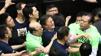 Anggota parlemen dari Partai Progresif Demokratik (DPP) berkelahi dengan Partai Nasionalis Tiongkok atau yang dikenal dengan Kuomintang (KMT) saat melakukan protes di Parlemen di Taipei (20/4). (AFP Photo/Sam Yeh)