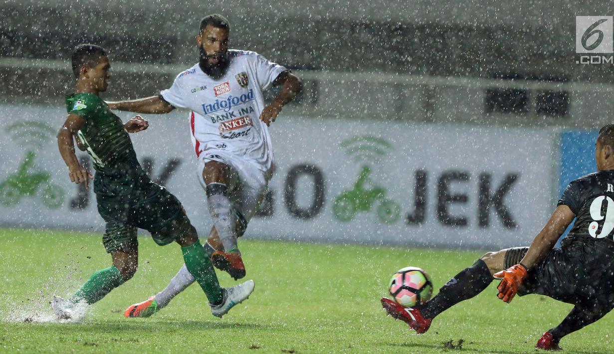Penyerang Bali United, Sylvano Dominique C (tengah) mengecoh kiper PS TNI Ravi Murdianto dilanjutan Liga 1 Indonesia di Stadion Pakansari, Kab Bogor, Senin (10/7). Laga dimenangkan Bali United dengan skor 4-3. (Liputan6.com/Helmi Fithriansyah)