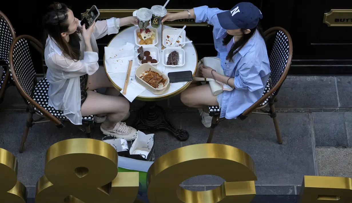 Seorang wanita bersulang dengan temannya di restoran yang dibuka kembali di sebuah pusat perbelanjaan di Beijing, Senin (6/6/2022). Pengunjung kembali ke restoran di sebagian besar Beijing untuk pertama kalinya dalam lebih dari sebulan sebagai pihak berwenang lebih lanjut melonggarkan pembatasan terkait pandemi wabah COVID-19. (AP Photo/Andy Wong)