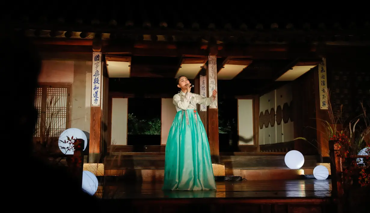 Seorang penampil menampilkan pertunjukan tradisional di secret garden Istana Changdeokgung dalam acara tur sinar rembulan di Seoul, pada 29 Oktober 2020. Istana Changdeokgung dianggap sebagai mahakarya arsitektur karena bangunannya yang selaras dengan kondisi alam sekitar. (Xinhua/Wang Jingqiang)