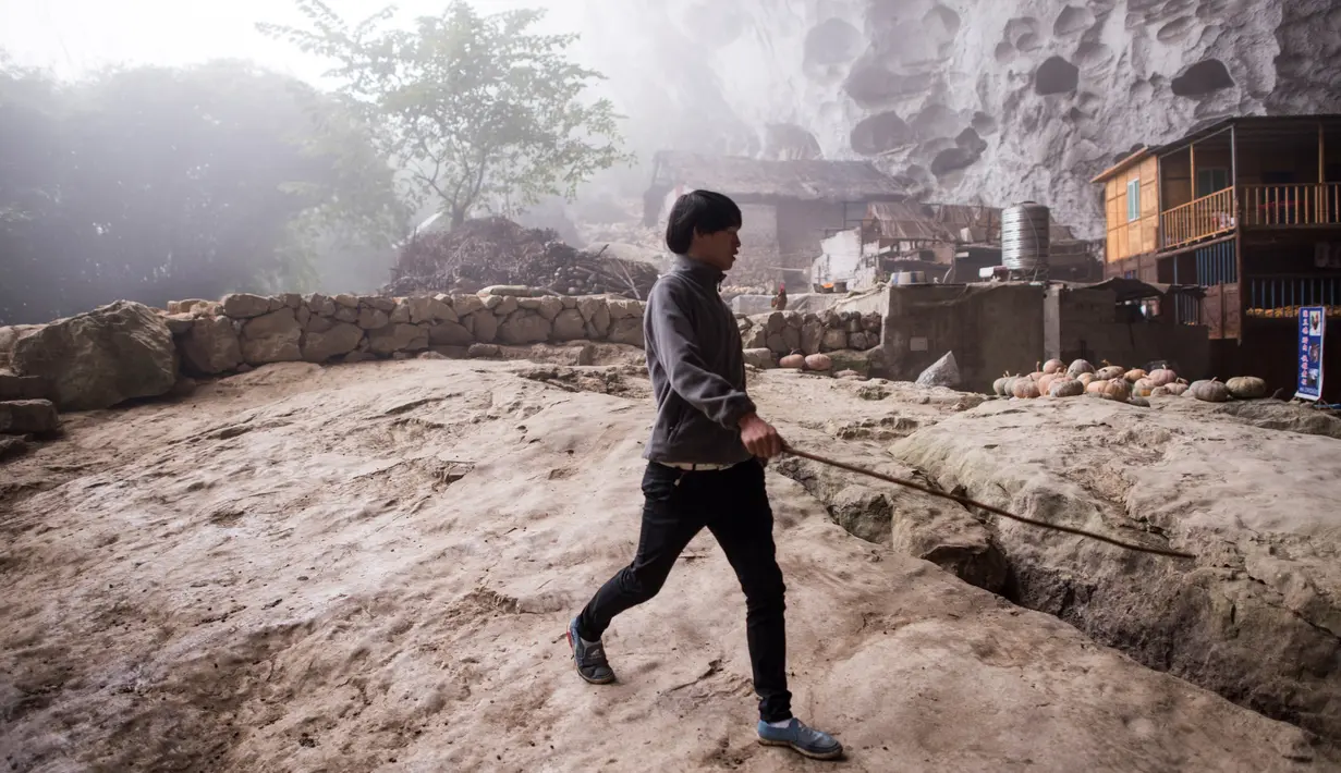 Seorang pria beraktivitas Desa Zhongdong yang berada di dalam gua, Provinsi Guizhou, China (6/10/2016). (Photo / FredDufour)