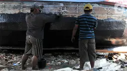 Pekerja menyelesaikan proses perbaikan kapal nelayan di pesisir Marunda, Jakarta, Selasa (22/10/2019). Jasa perbaikan kapal nelayan merupakan salah satu mata pencaharian utama warga pesisir Marunda selain mencari ikan di laut. (merdeka.com/Iqbal Nugroho)