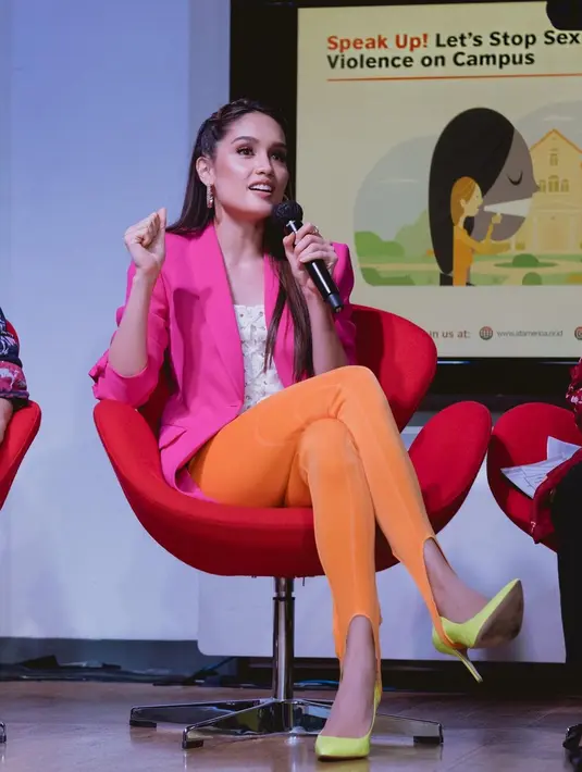 Di foto ini, terlihat Cinta Laura sedang menjadi pembicara dengan outfit yang colorful. Dengan innerwear putih, ia lapisi dengan blazer pink, dan mengenakan legging pants orange, yang kemudian dipadu dengan heels kuning. Foto: Instagram.