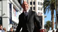 Dwayne Johnson berpose di sebuah plakat bintang atas namanya dari Hollywood Walk of Fame di Los Angeles, Jumat (13/12). The Rock mengungkapkan rasa bahagianya atas pemberian bintang ini lewat akun media sosialnya. (Photo by Willy Sanjuan/Invision/AP)