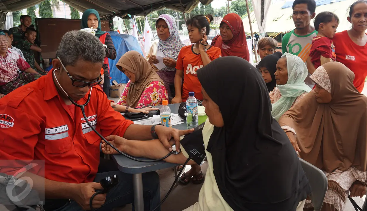 Petugas Tim SAR Sampoerna memeriksa warga korban banjir bandang dan gempa di Bima, Nusa Tenggara Barat (05/1). Sebagian warga menderita penyakit gatal-gatal dan cacar air. (Liputan6.com/Istimewa)