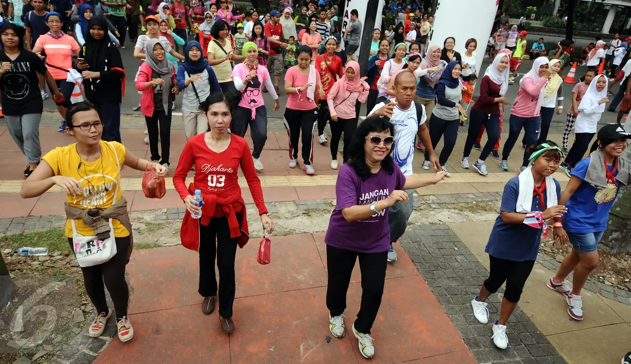 Puluhan peserta menari poco poco usai mengikuti Tolerun 2016 di kawasan Jalan Jenderal Sudirman, Jakarta, Minggu (20/11). Ratusan orang berlari merayakan toleransi keberagaman dalam Tolerun 2016. (Liputan6.com/Helmi Fithriansyah) 