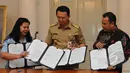 Gubernur DKI Jakarta Basuki T Purnama memperlihatkan nota kesepahaman (MoU) yang telah ditandatangi dengan pihak BPJS di Balaikota, Jakarta, Rabu (1/4/2015).  (Liputan6.com/Herman Zakharia)