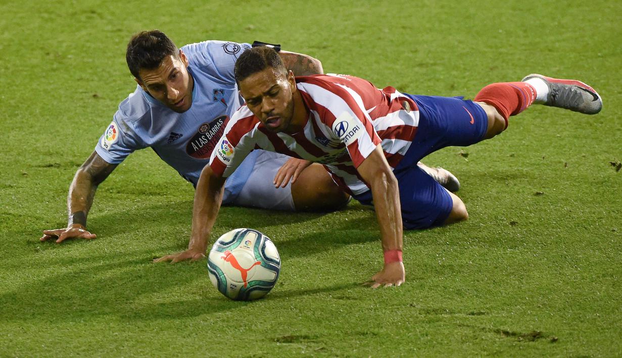 Bek Atletico Madrid, Renan Lodi, berebut bola dengan bek Celta Vigo, Hugo Mallo, pada laga lanjutan La Liga di Abanca-Balaidos, Rabu (8/7/2020) dini hari WIB. Atletico Madrid ditahan imbang 1-1 oleh Celta Vigo. (AFP/Miguel Riopa)