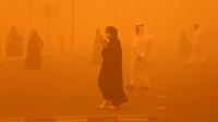Pejalan kaki menyeberang jalan di tengah badai debu parah di Kota Kuwait pada 23 Mei 2022. Badai pasir telah melanda Timur Tengah dalam beberapa hari terakhir, dan menjadi fenomena yang para ahli peringatkan dapat berkembang luas karena perubahan iklim. (Yasser Al-Zayyat / AFP)