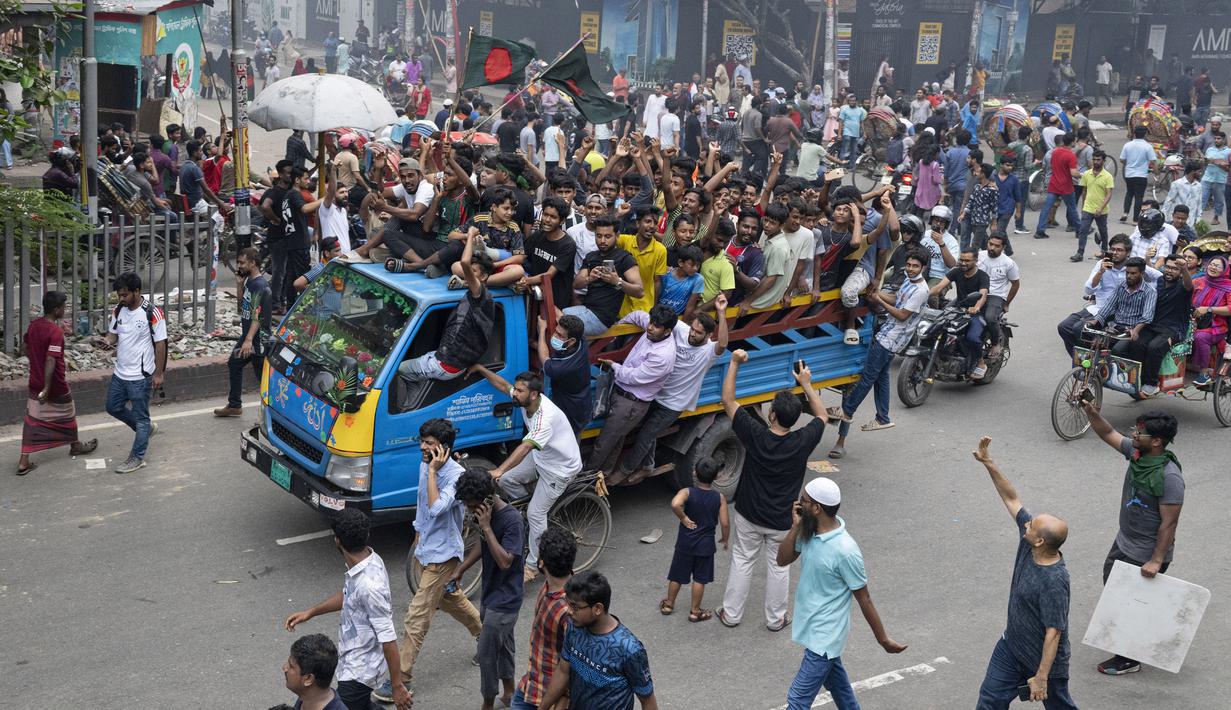 Massa yang tampak gembira mengibarkan bendera di jalan-jalan Dhaka, sebelum ratusan orang menerobos gerbang kediaman resmi Syekh Hasina. (AP Photo/Fatima Tuj Johora)