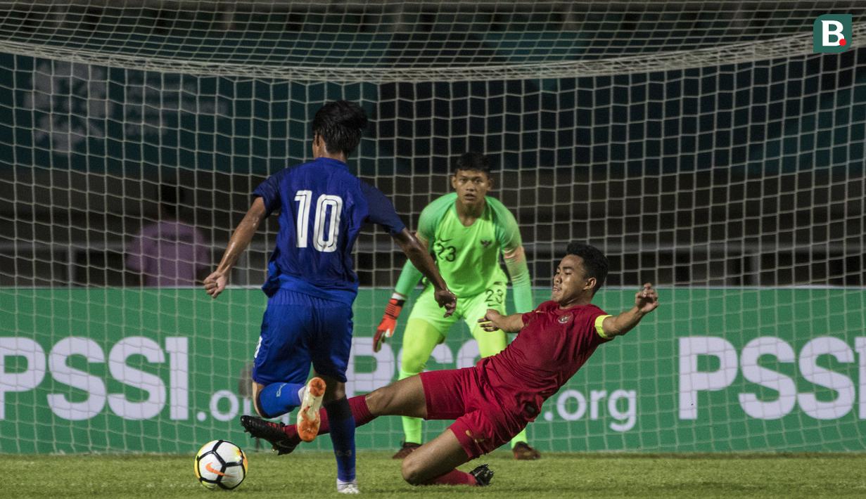 Bek Timnas Indonesia, Nurhidayat Haris, menekel gelandang Thailand, Hassawat Nopnate, pada laga PSSI 88th U-19 di Stadion Pakansari, Jawa Barat, Minggu (23/9/2018). Kedua negara bermain imbang 2-2. (Bola.com/Vitalis Yogi Trisna)