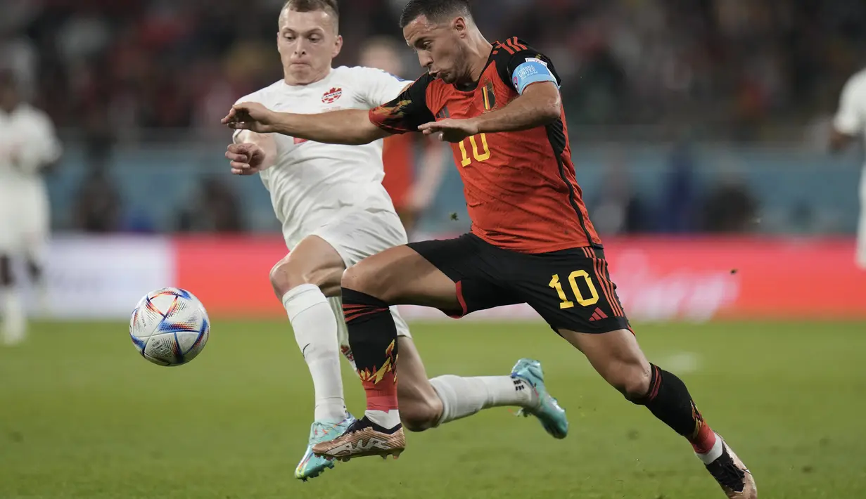 Gelandang Belgia, Eden Hazard berusaha melewati pemain Kanada, Alistair Johnston pada pertandingan grup F Piala Dunia 2022 Qatar di Stadion Ahmad Bin Ali di Doha, Qatar, Kamis (24/11/2022). Belgia menang tipis atas Kanada 1-0. (AP Photo/Hassan Ammar)