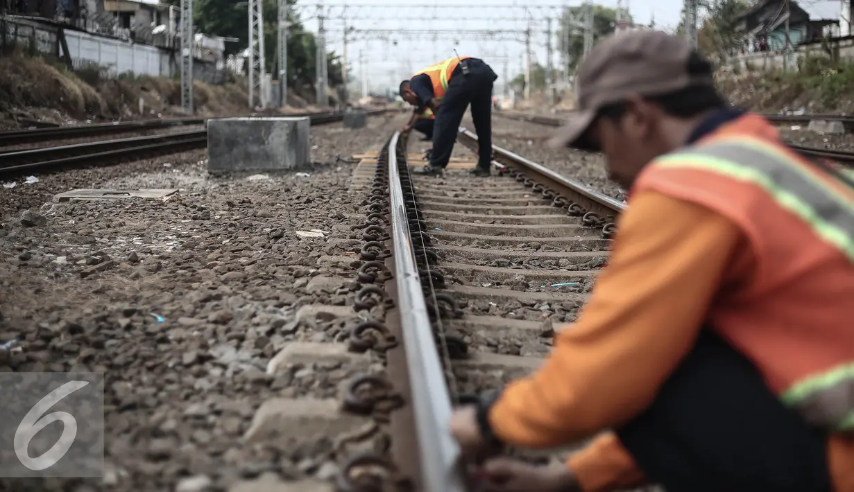 Petugas mengukur rel pasca (KRL) Commuter Line Bogor-Tanah Abang yang anjlok diantara km 5+4di jalur Manggarai arah Sudirman, Jakarta, Rabu (18/5). KRL ka 1517 anjlok pada pukul 06.18 di km 5+4. (Liputan6.com/Faizal Fanani)