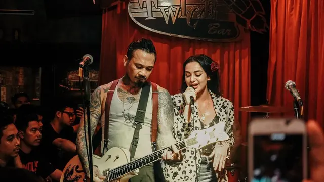 Jerinx SID mengiringi lantunan suara sang istri, Nora Alexandra usai keluar dari penjara. Terlihat wajah Nora yang bahagia bisa manggung bareng suami. (Foto: Instagram/@ncdpapl)