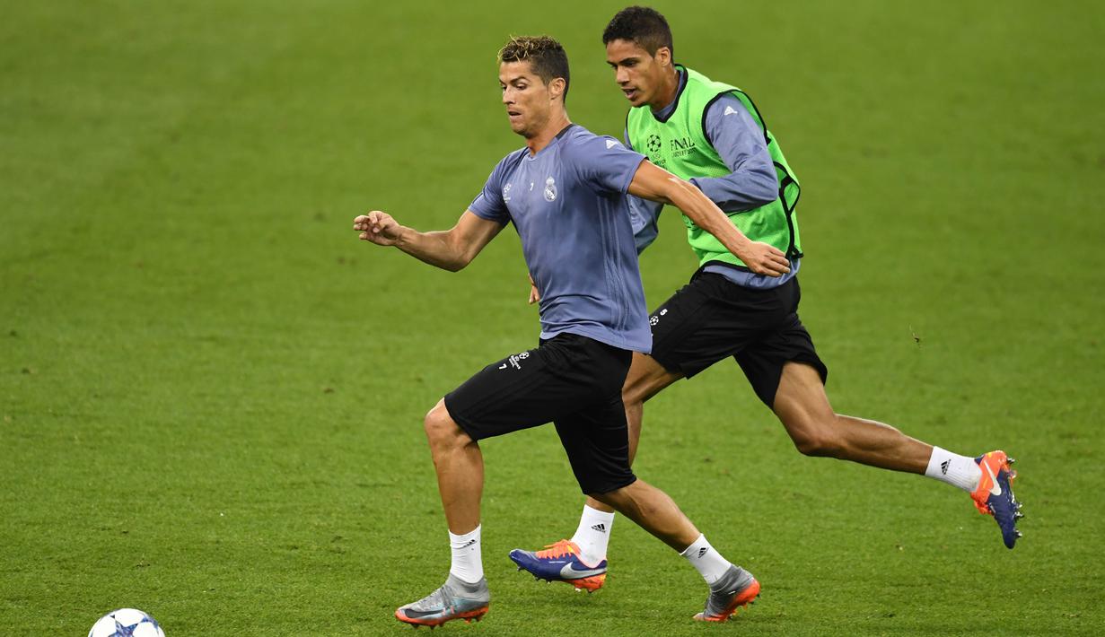 Aksi pemain Real Madrid, Cristiano Ronaldo (kiri) dan Raphael Varane pada sesi latihan jelang final Liga Champions di Principality Stadium, Cardiff, Wales Selatan, (2/6/2017). (AFP/Glyn Kirik)