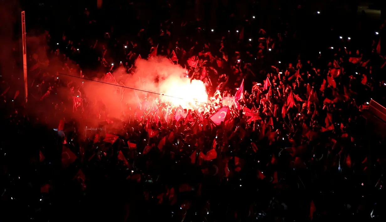 Flare dinyalakan para pendukung Presiden Turki Tayyip Erdogan saat merayakan kegagalan kudeta militer di Taksim Square, pusat kota Istanbul, Sabtu (16/7). Pihak militer berupaya melakukan kudeta terhadap Pemerintahan Erdogan (REUTERS/Alkis Konstantinidis)