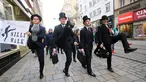 Sejumlah pria mengenakan kostum berjalan dengan mengangkat tinggi kakinya di Brno, Republik Ceko (7/1). Mereka berjalan dengan mengenakan kostum tersebut dalam acara International Silly Walk Day.  (AFP Photo/Radek Mica)