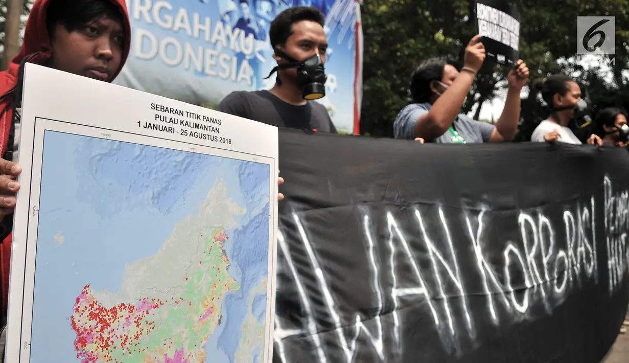 Aktivis WALHI  membentangkan spanduk dalam aksi protes pembakaran hutan di depan Kantor KLHK, Jakarta, Senin (27/8). WALHI menuntut pemerintah menegakkan hukum bagi korporasi pembakar hutan yang berlangsung setiap tahun. (Merdeka.com/Iqbal S. Nugroho)