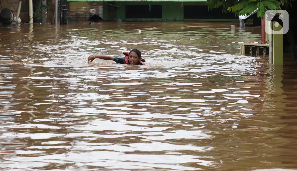 Anak-anak berenang di salah satu gang di Kawasan Rawajati yang tergenang banjir, Jakarta, Rabu Rabu (1/1/2020). Hujan yang mengguyur Jakarta sejak Selasa sore (31/12/2019) mengakibatkan banjir di sejumlah titik di Jakarta. (Liputan6.com/Helmi Fithriansyah)