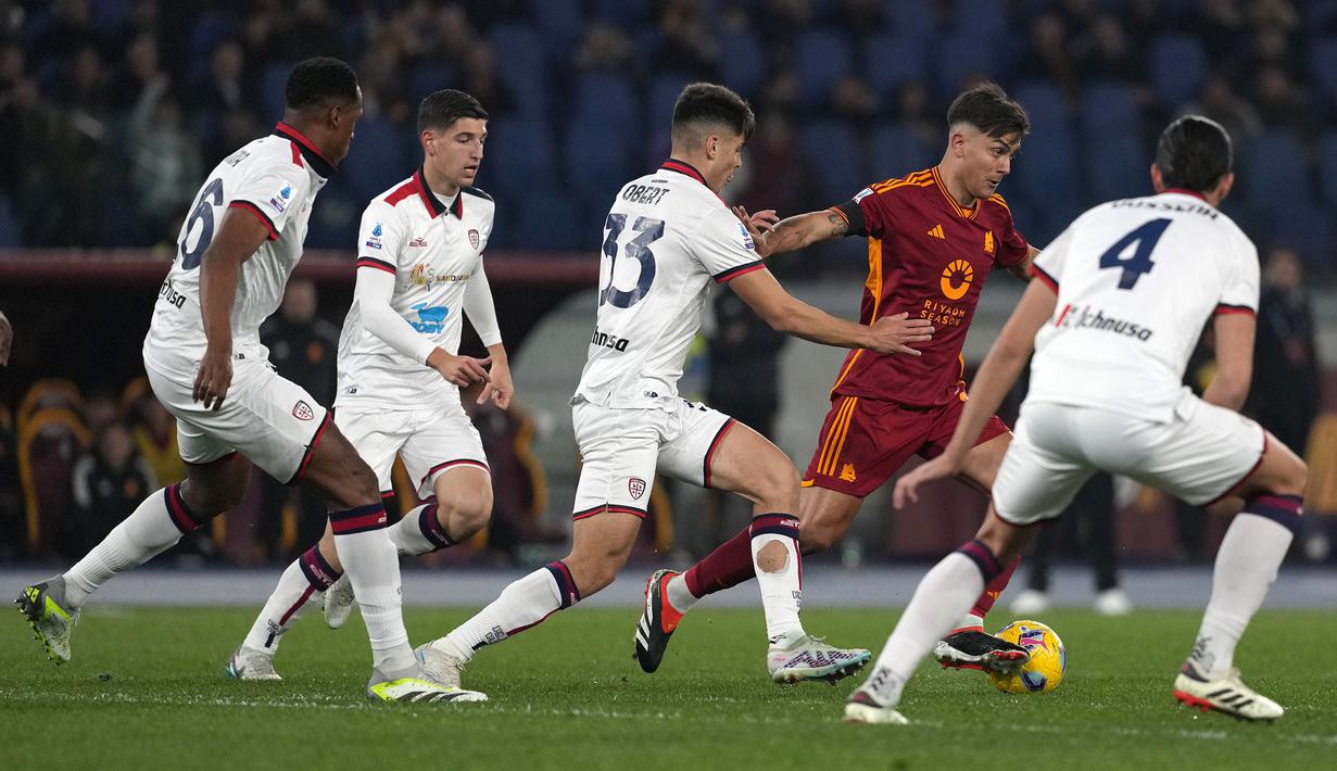 Pemain AS Roma, Paulo Dybala (kedua kanan) berusaha melewati sejumlah pemain Cagliari pada laga lanjutan Liga Italia 2023/2024 di Olympic Stadium, Roma, Italia, Selasa (06/02/2024) dini hari WIB. (AP Photo/Andrew Medichini)
