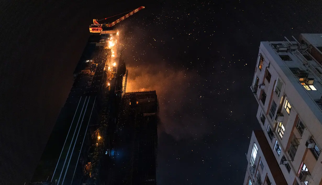 Kebakaran melanda lokasi konstruksi di Hong Kong, Jumat (3/3/2023). Kebakaran melanda lantai atas gedung pencakar langit yang sedang dibangun di daerah Tsim Sha Tsui, Hong Kong, dini hari waktu setempat. (AP Photo/Louise Delmotte)
