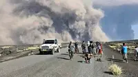 Foto yang dirilis oleh Biro Komunikasi Pemerintah Afar ini menunjukkan warga menyaksikan abu yang membubung dari letusan Gunung Berapi Hayli Gubbi yang telah lama tidak aktif di wilayah Afar, Ethiopia, pada Minggu (23/11/2025). (Biro Komunikasi Pemerintah Afar via AP)