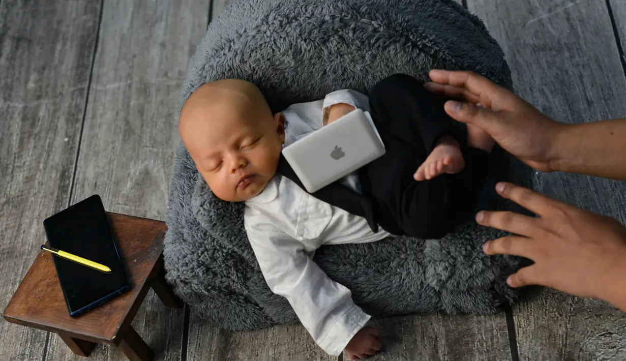 Seorang bayi yang baru lahir saat menjalani sesi foto di Banda Aceh pada 18 November 2019. Merekam momen bayi baru lahir lewat fotografi belakangan sedang menjadi tren para orangtua baru di Indonesia. (Photo by CHAIDEER MAHYUDDIN / AFP)