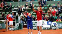 Petenis Serbia, Novak Djokovic, berselebrasi dengan ball boy seusai mengalahkan Roberto Bautista Agut pada babak 16 besar Prancis Terbuka, Rabu (1/6/2016). (EPA/Yoan Valat)