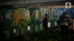 Mahasiswa Institut Kesenian Jakarta (IKJ) menyelesaikan pembuatan mural di kolong Jembatan Pegangsaan, Menteng, Jakarta, Selasa (26/1/2021). Pembuatan mural tersebut merupakan bagian dari pembangunan taman kolong jembatan oleh Pemprov DKI Jakarta. (Liputan6.com/Faizal Fanani)