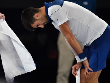 Petenis Serbia, Novak Djokovic tertunduk karena  kehilangan poin saat melawan petenis asal Korea, Hyeon Chung pada ajang Australia Terbuka 2018 di Melbourne,  (22/2/2018). Djokovic kalah 6-7, 5-7, 6-7. (AFP/Paul Crock)