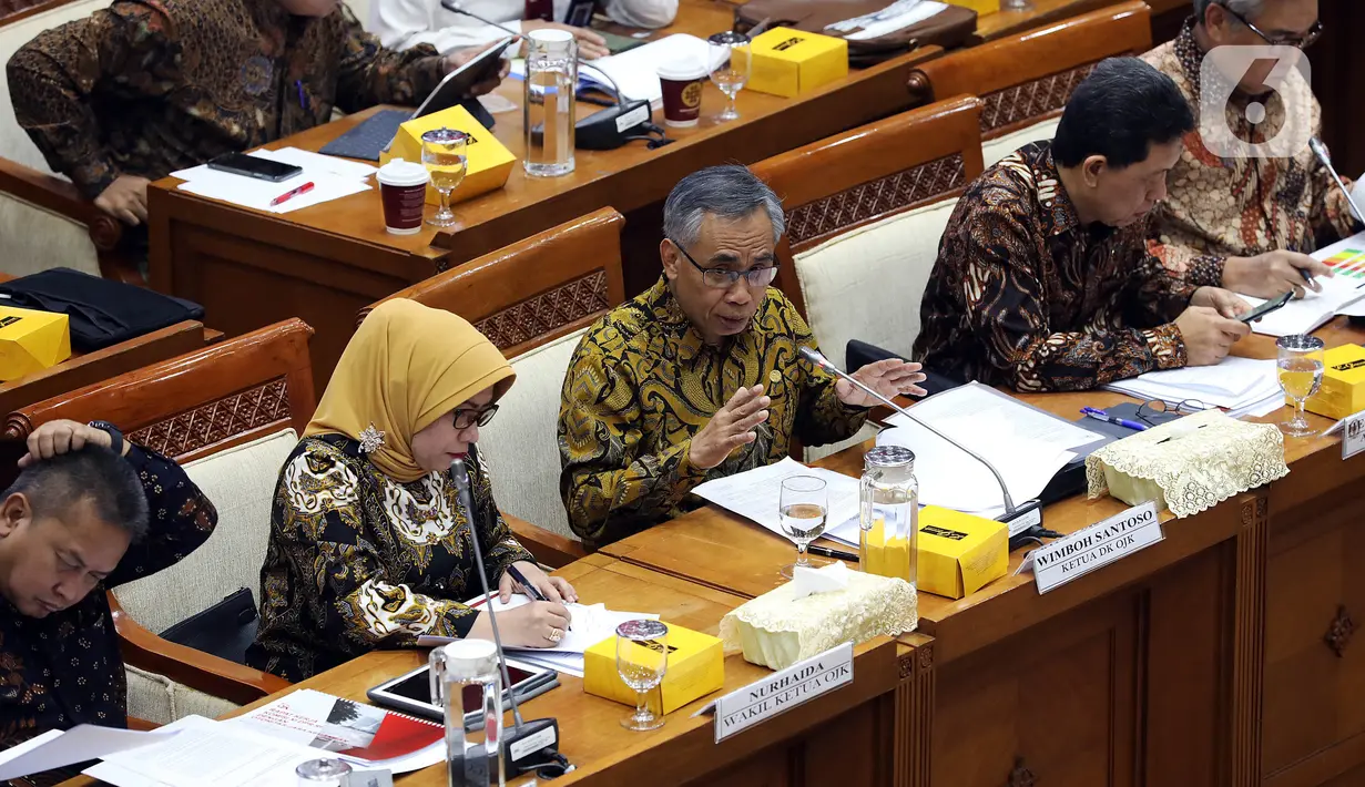 Ketua Dewan Komisioner OJK Wimboh Santoso (tengah) menyampaikan pemaparan saat rapat dengan Komisi XI DPR terkait pembenahan Jiwasraya di Kompleks Parlemen, Jakarta, Rabu (22/1/2020). Rapat tersebut juga membahas tentang pengawasan industri jasa keuangan. (Liputan6.com/Johan Tallo)